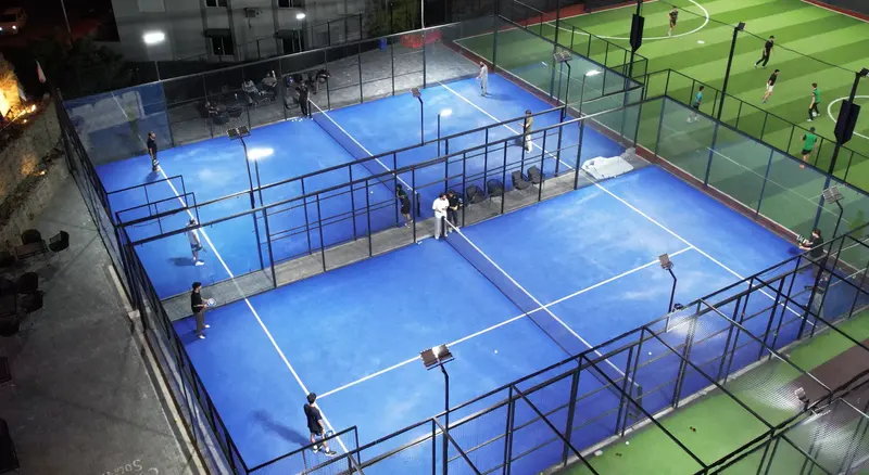 The two illuminated blue padel courts at NETX