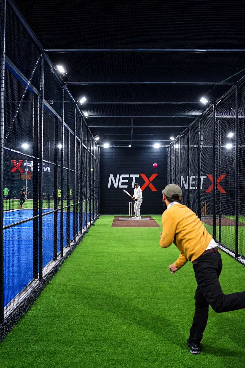 A bowler delivering a ball in a NETX bowling machine lane